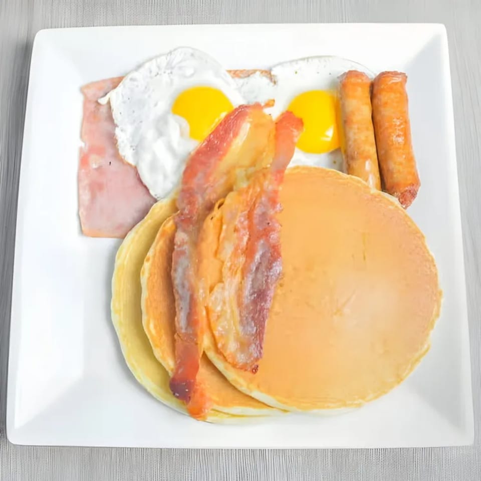 Shore Road Diner's breakfast platter with pancakes, bacon, sausage, ham, and two fried eggs.